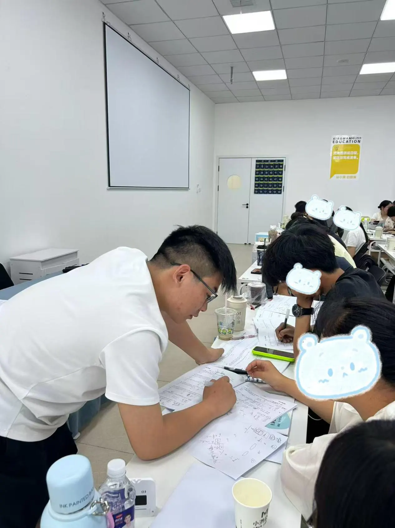 晚自习在教室里，助教俯身在学员座位旁答疑